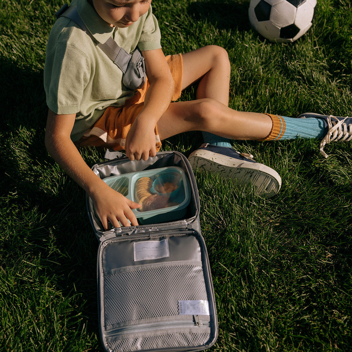 Gray insulated kids' lunch box, open lid showing mesh top and silver interior