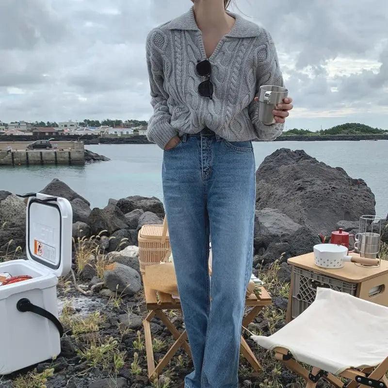 Gray-blue cable knit sweater with turn-down collar, worn with blue jeans