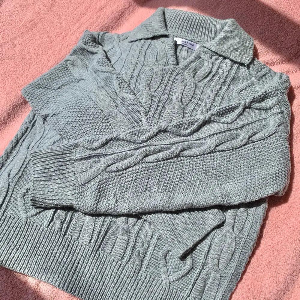Gray-blue cable knit sweater with turn-down collar and wide ribbed cuffs
