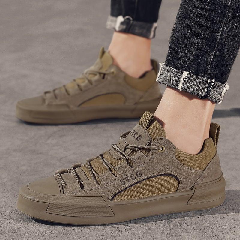 Men's tan low-top lace-up sneakers on feet with thick rubber sole