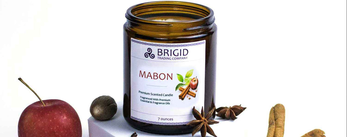 Scented soy candle jar with black lid, BRIGID label, autumn spice and leaves