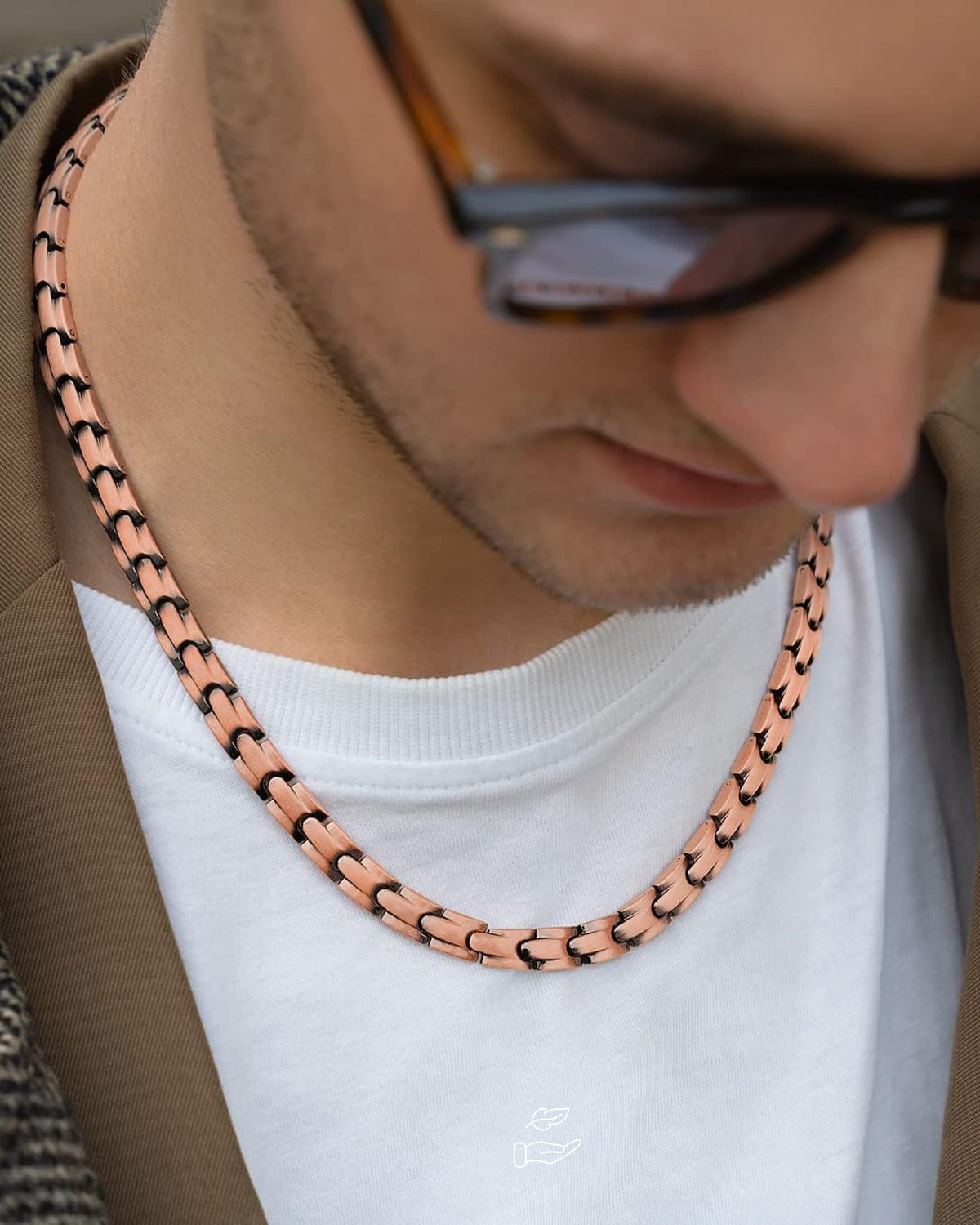 Copper magnetic therapy necklace link chain on white T-shirt, side close-up