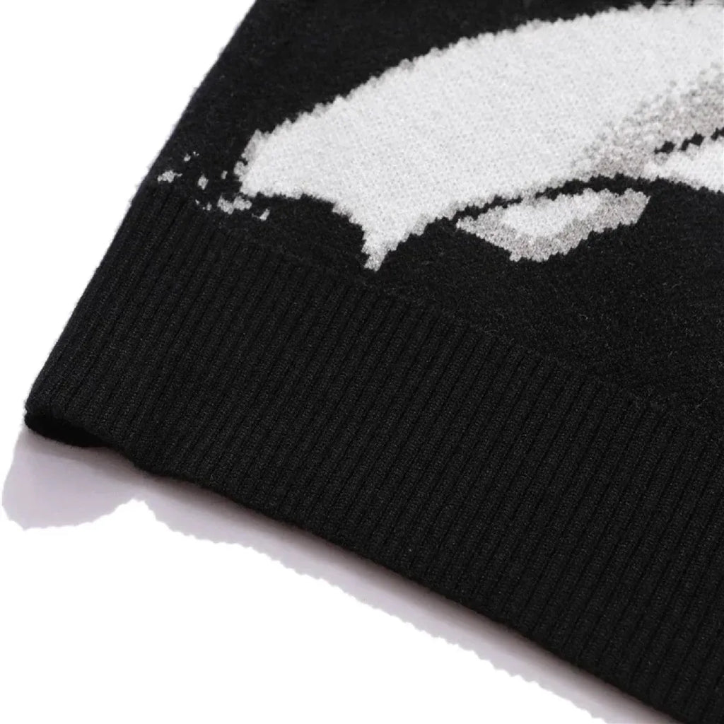 Black ribbed knit cuff with white graphic detail at sweater hem