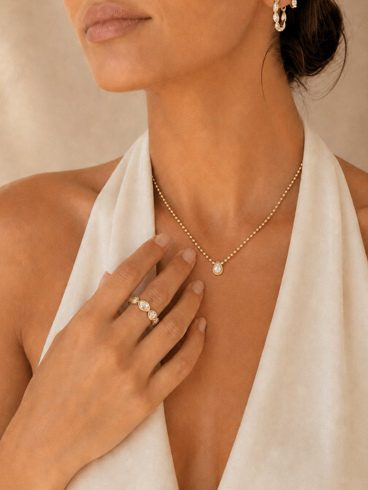 Gold beaded teardrop diamond necklace with pendant shown near the collarbone