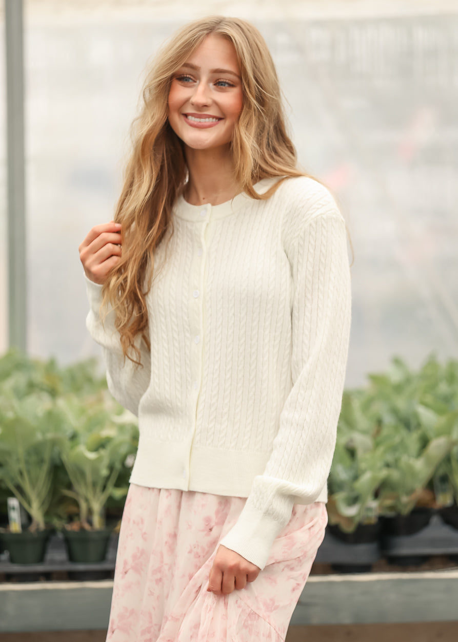 White knit cardigan with button front and cable pattern, long sleeves