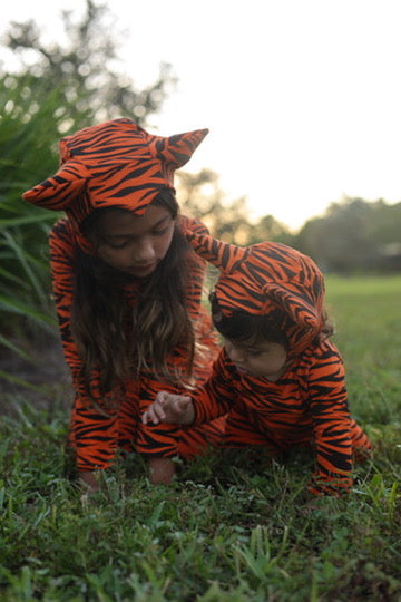 Orange tiger costume hooded jumpsuit with black stripes on two babies playing