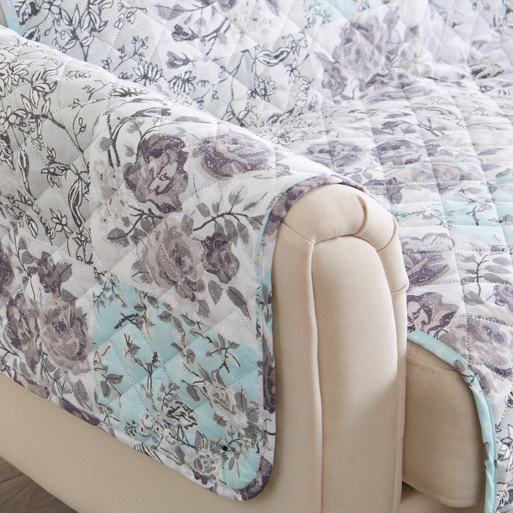 Reversible floral patchwork furniture protector on sofa arm, quilted white with light blue and purple