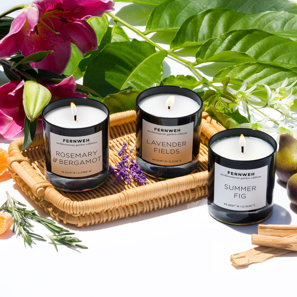 Candle gift set with three black-lidded scented candles on a wicker tray