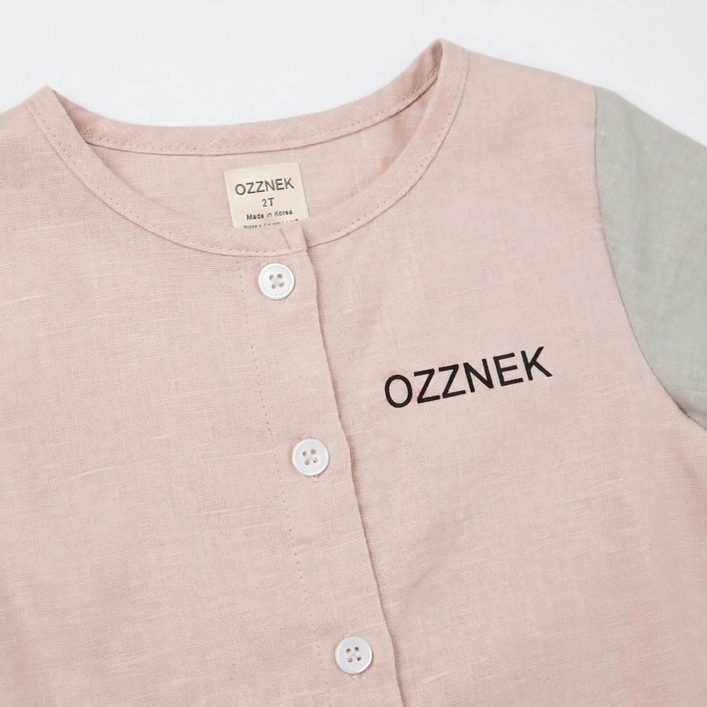 Toddler linen button-up shirt close-up, light pink with front buttons; OZZNEK