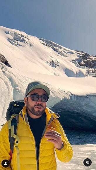 Men's yellow puffer alpaca jacket with full-zip and hood, worn outdoors