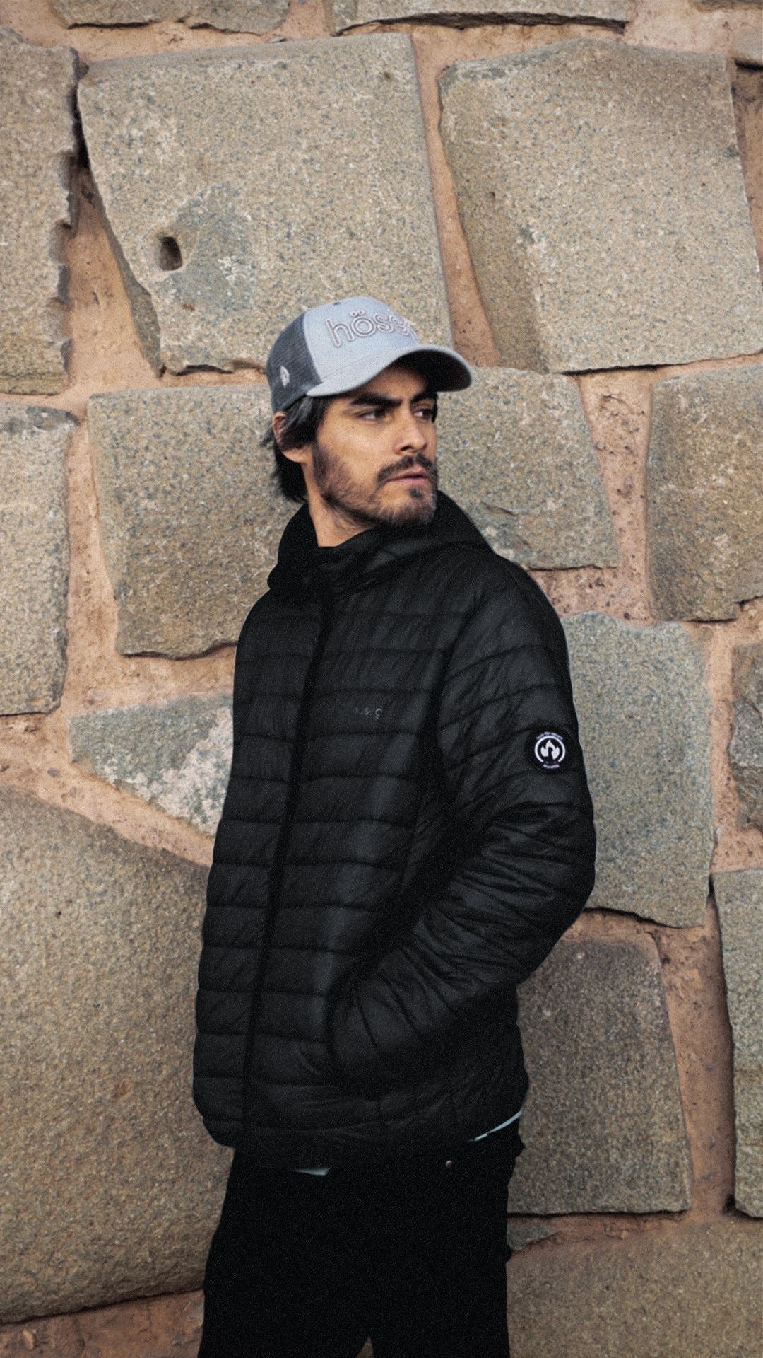 Black men's puffer jacket with quilted baffles, stand collar, and full zip