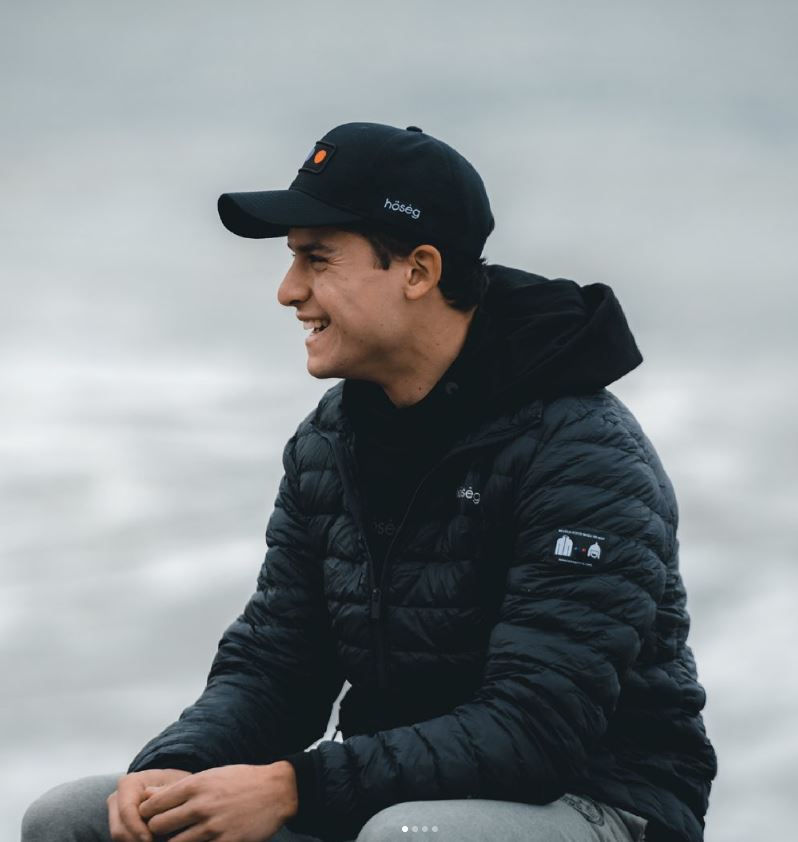 Black puffer jacket with hood and small sleeve logo patch