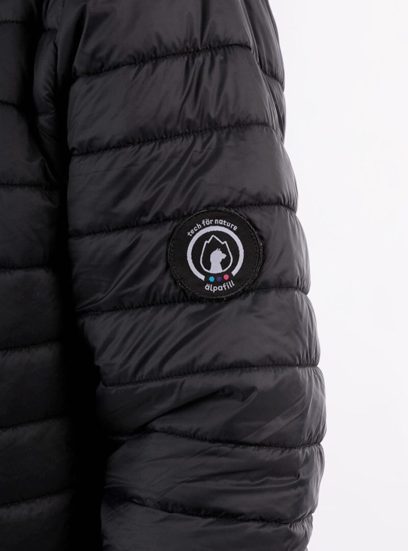 Black quilted puffer jacket sleeve with round logo patch and stitched paneling