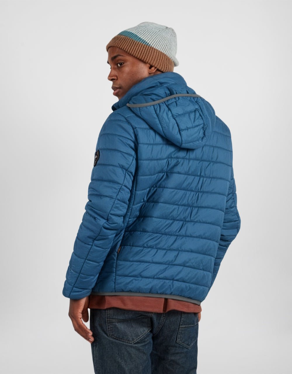 Men's blue puffer alpaca jacket, side view with hood and knit cuff trim