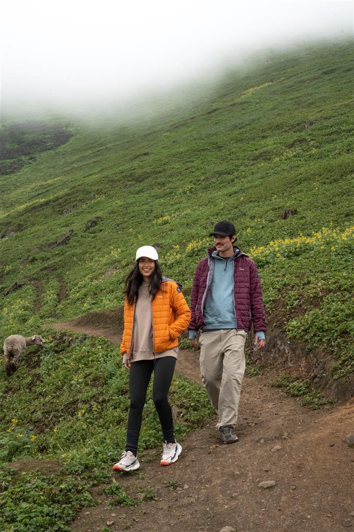 Men's plum puffer alpaca jacket on model outdoors, hooded full-zip