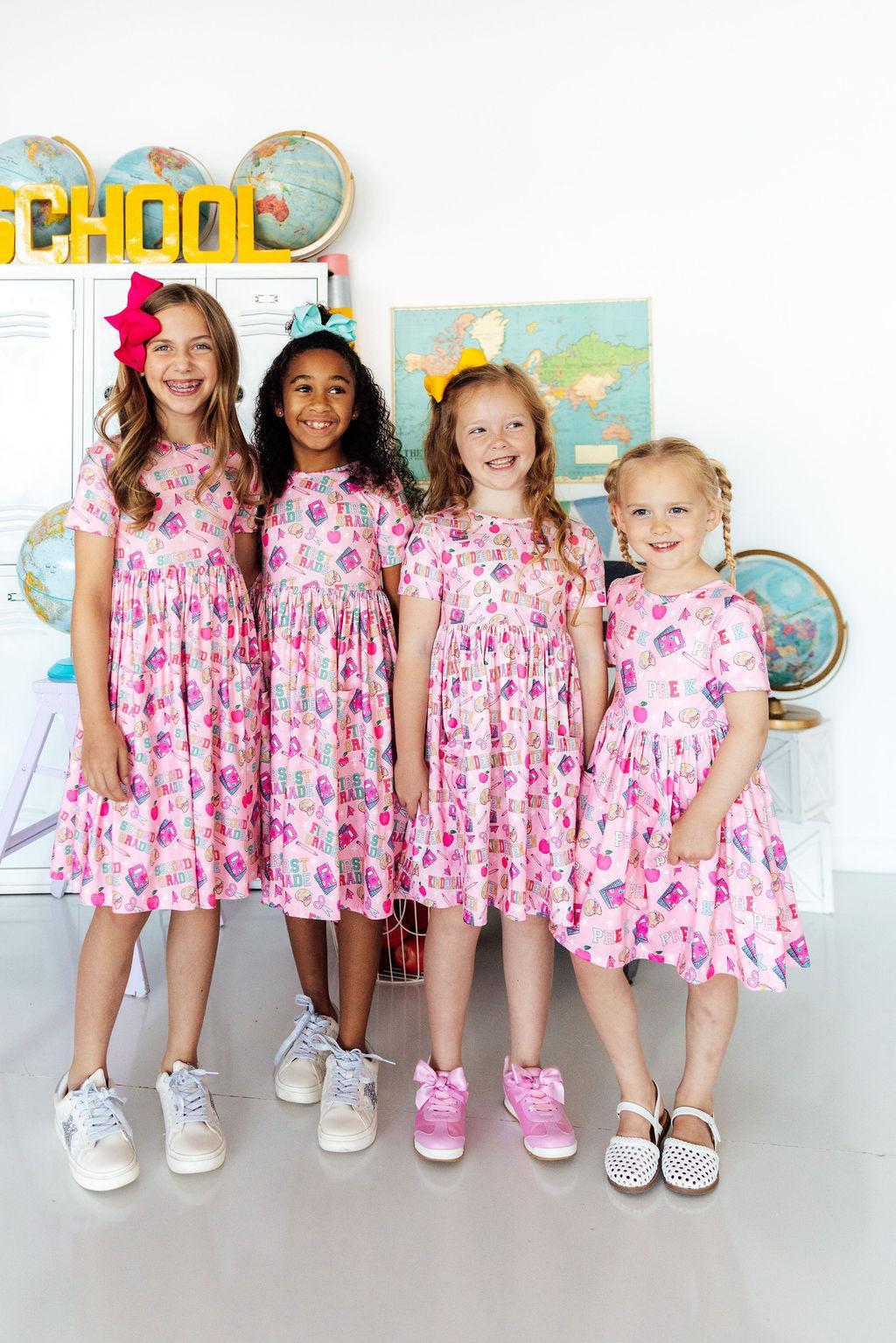 Pink short-sleeve twirl dress with front pockets and colorful graphic print