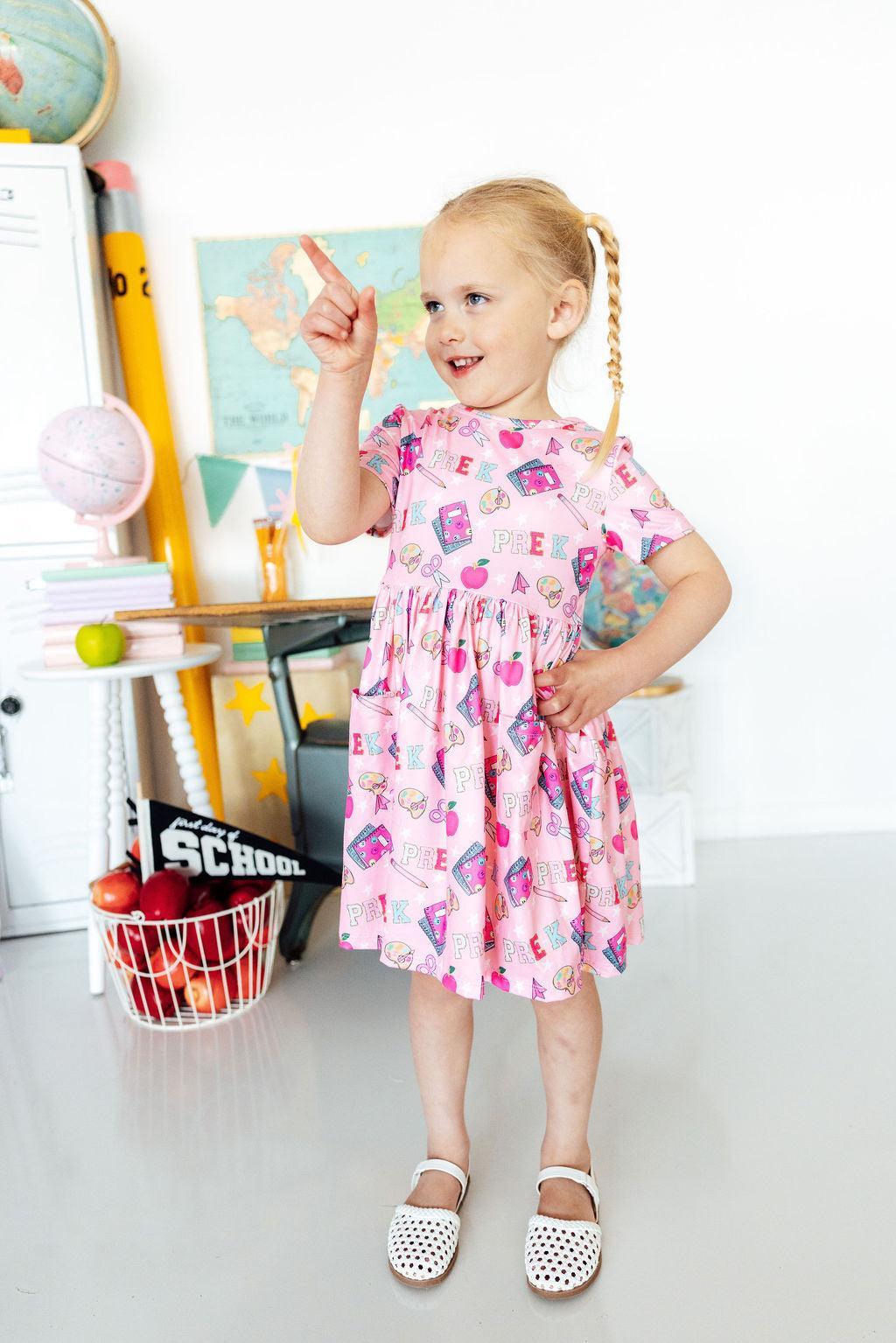 Girls pink short-sleeve twirl dress with front pocket and colorful graphic print