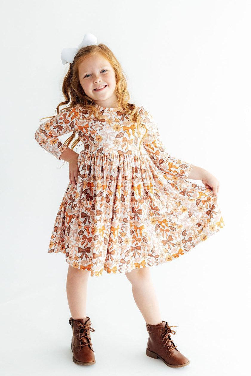 Orange floral long-sleeve twirl dress with twirled skirt, gathered waist detail
