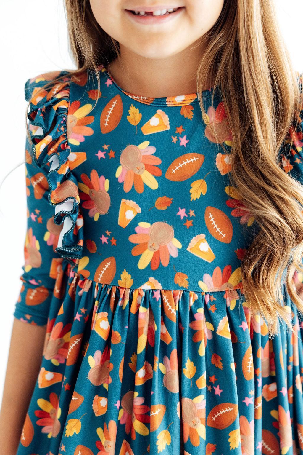 Teal girls’ 3/4 sleeve ruffle twirl dress with orange and peach leaf print