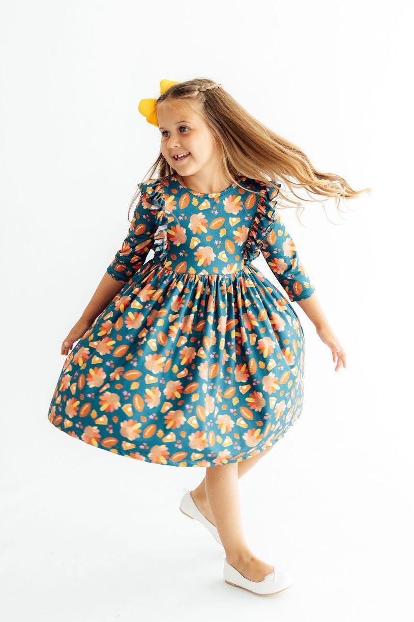 Teal gathered-waist twirl dress with 3/4 ruffle sleeves and allover orange peach print