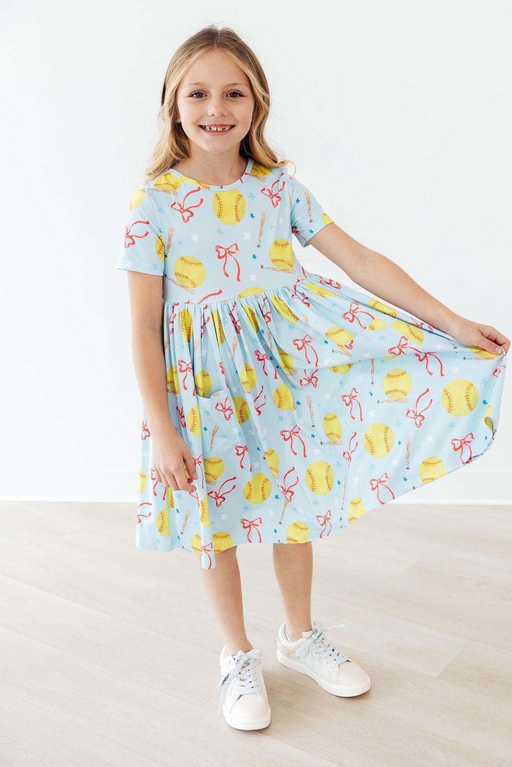 Light blue short-sleeve twirl dress with playful softball and bow print, twirled skirt