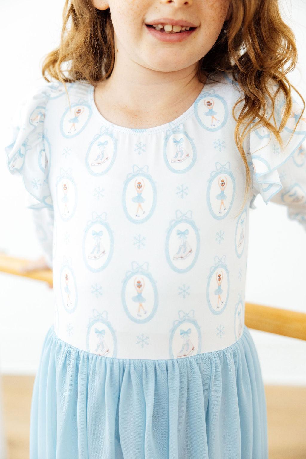 Light blue long-sleeve leotard with penguin and snowflake pattern and gathered tulle hem