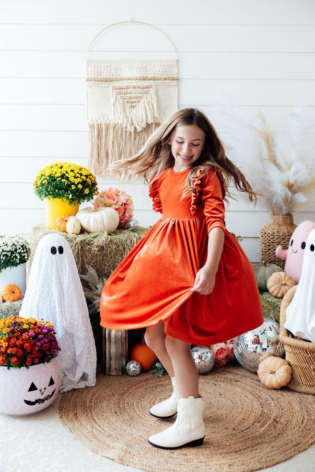 Orange velvet twirl dress with ruffle sleeves, gathered waist, and twirly skirt