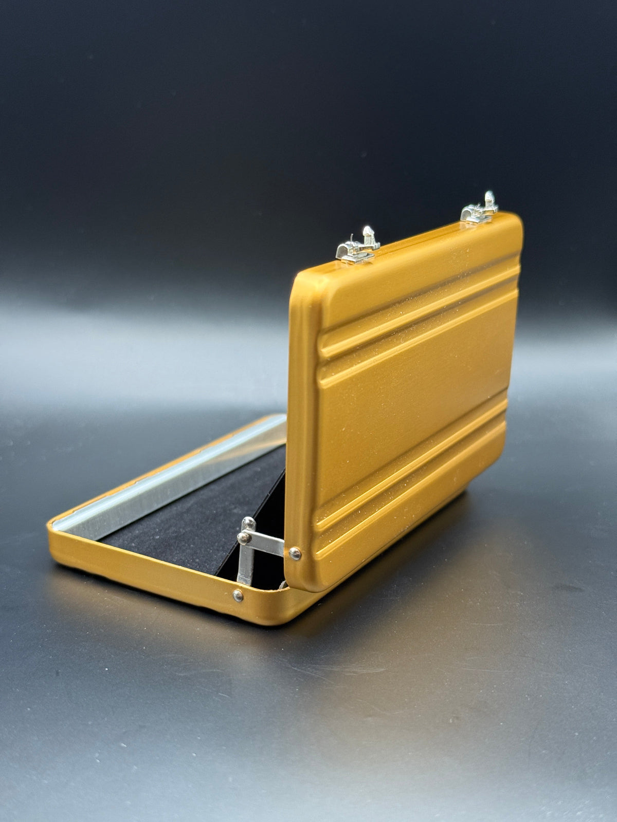 Gold mini briefcase with open lid and front clasp, angled view.