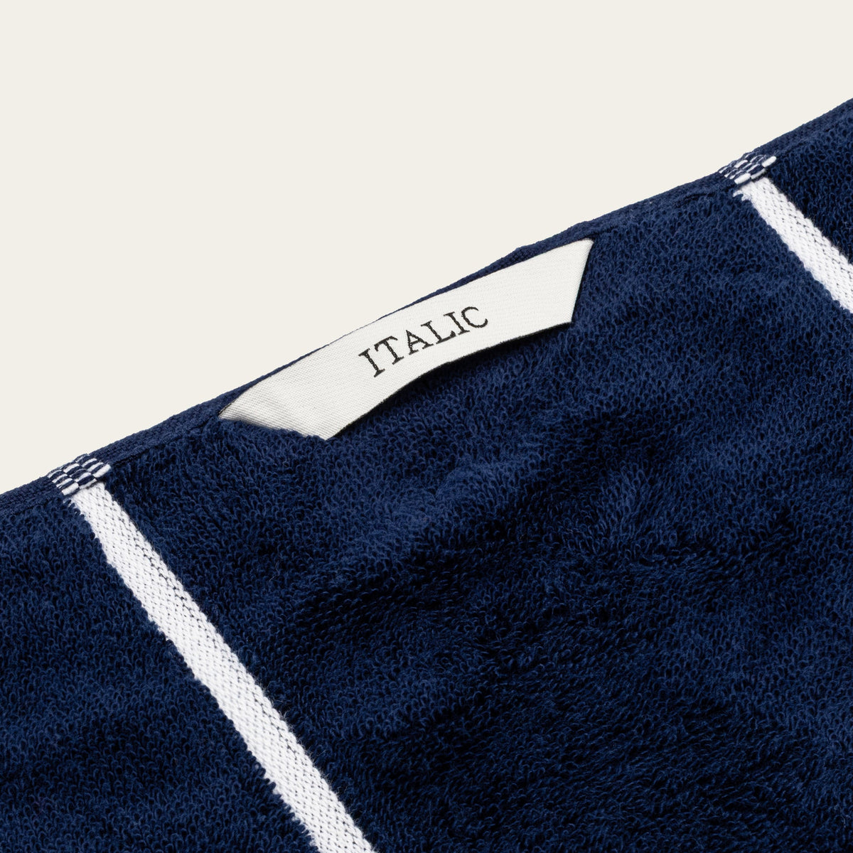 Navy cotton towel with white stripe trim and woven ITALIO label