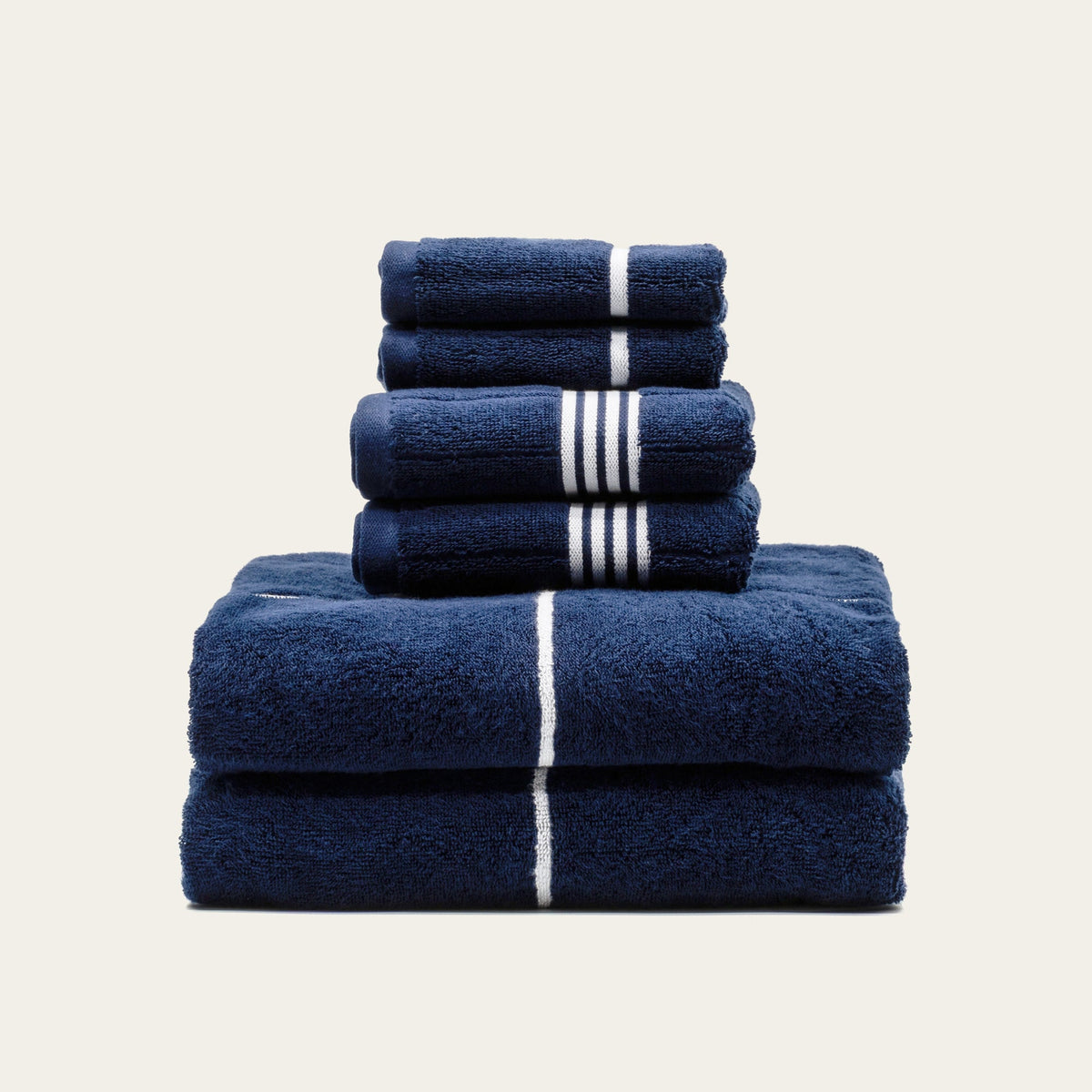 Stack of navy cotton towels with white stripe bands