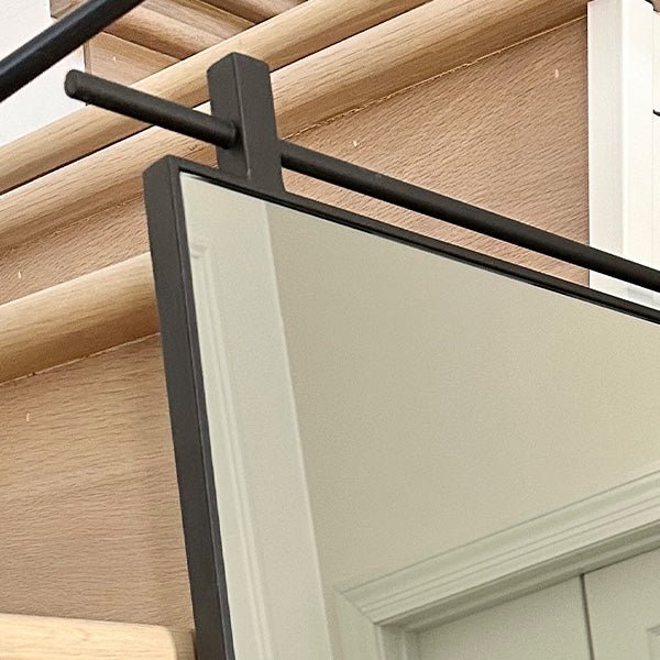 Rectangular mirror close-up with black metal top bar and frame