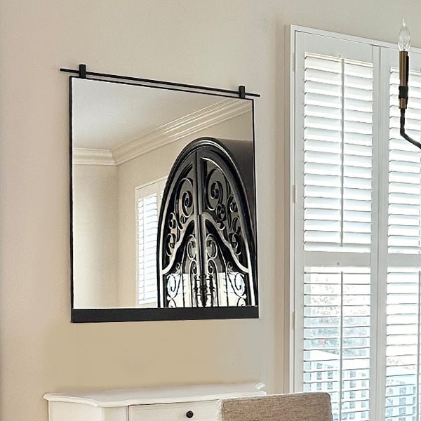 Rectangular wall mirror with black metal frame and clear reflective glass