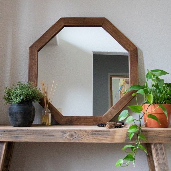 Octagon wood frame mirror with brown octagonal frame and clear glass against wall
