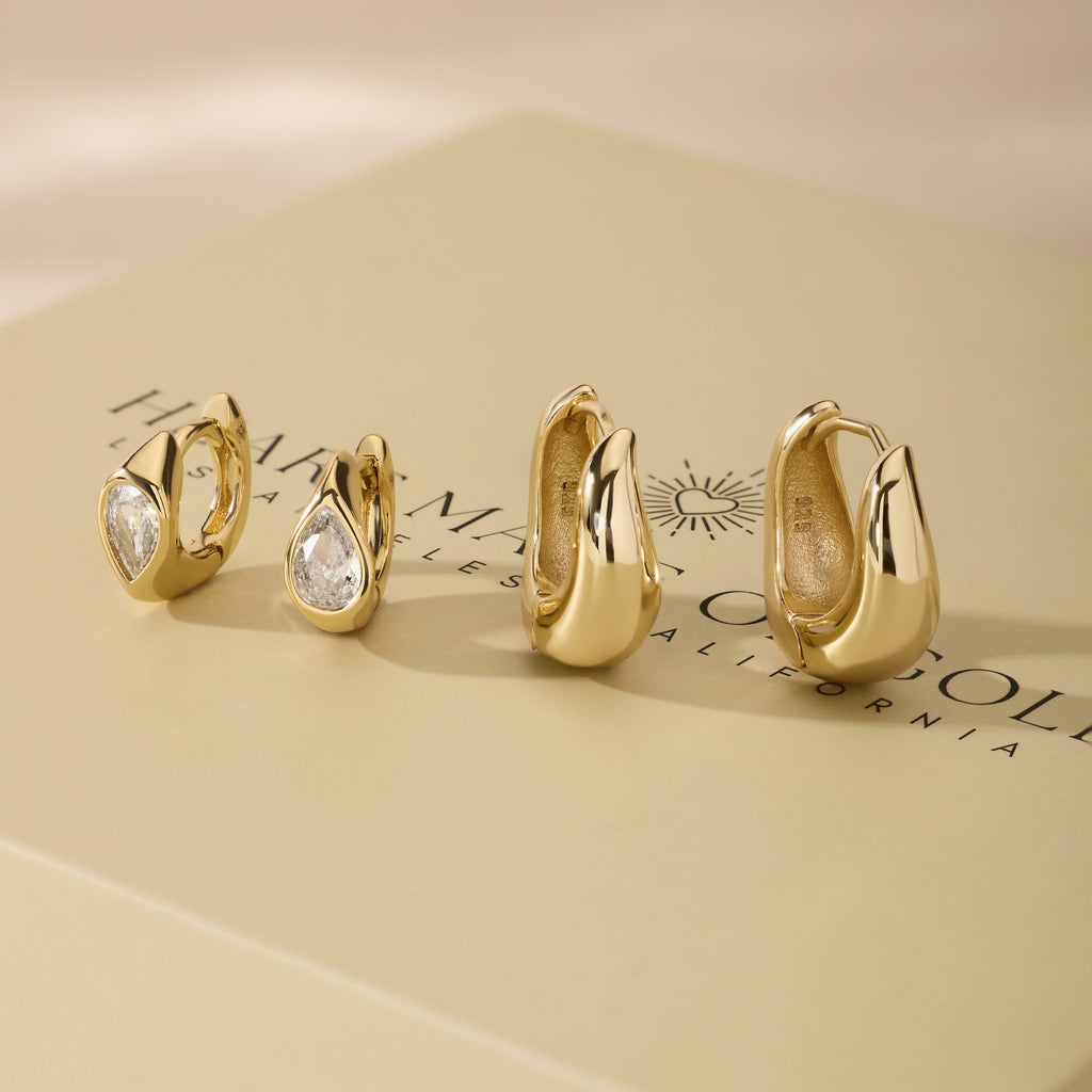 Wavy gold hoop earrings set with clear cubic zirconia stones, assorted sizes