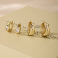 Wavy gold hoop earrings set with clear cubic zirconia stones, assorted sizes