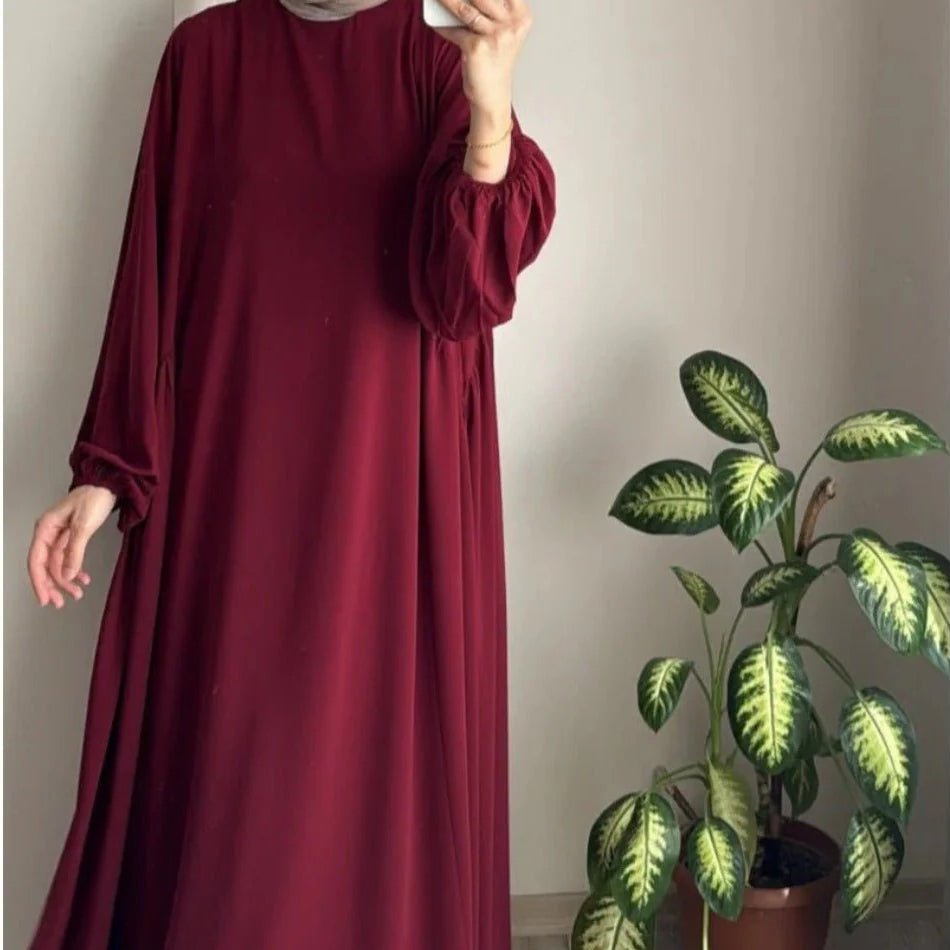 Burgundy loose-fit pullover abaya with gathered lantern sleeves and skirt pleats