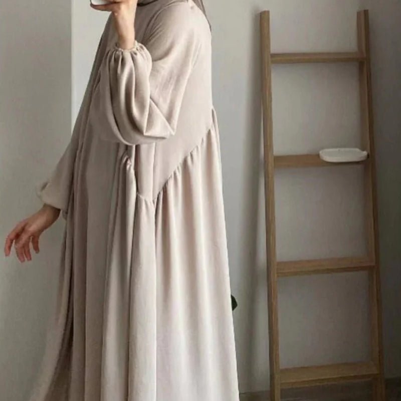 Beige loose-fit abaya with hood, lantern sleeves, and gathered waist pleats