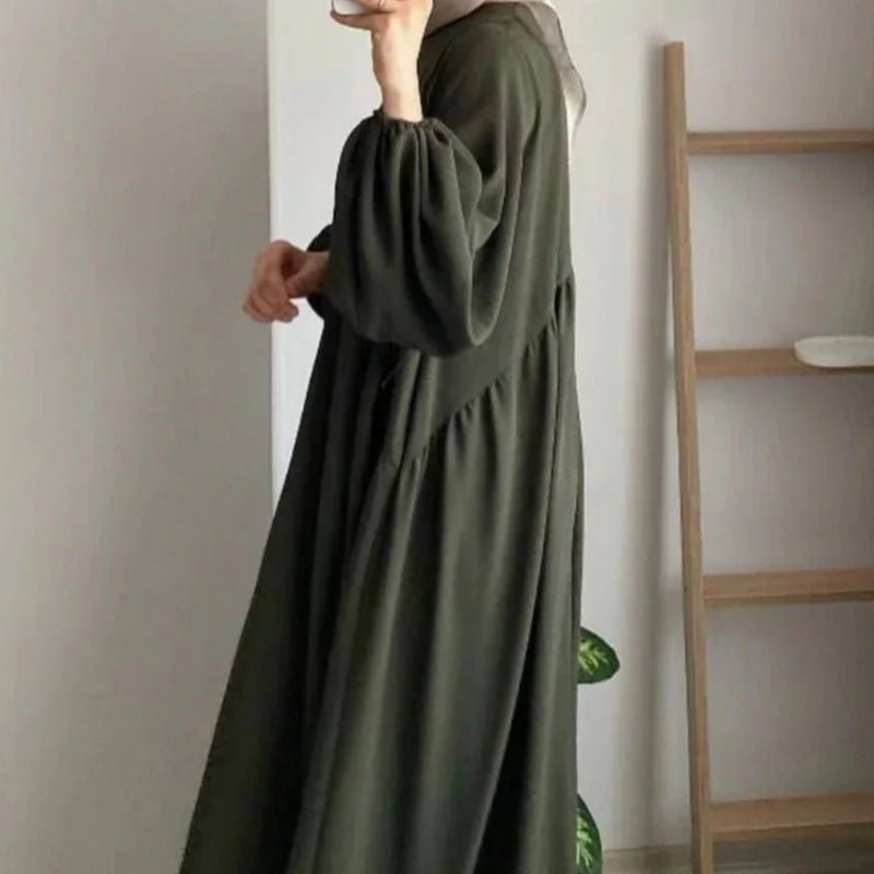 Olive abaya three-quarter view showing lantern sleeves and flowing pleats