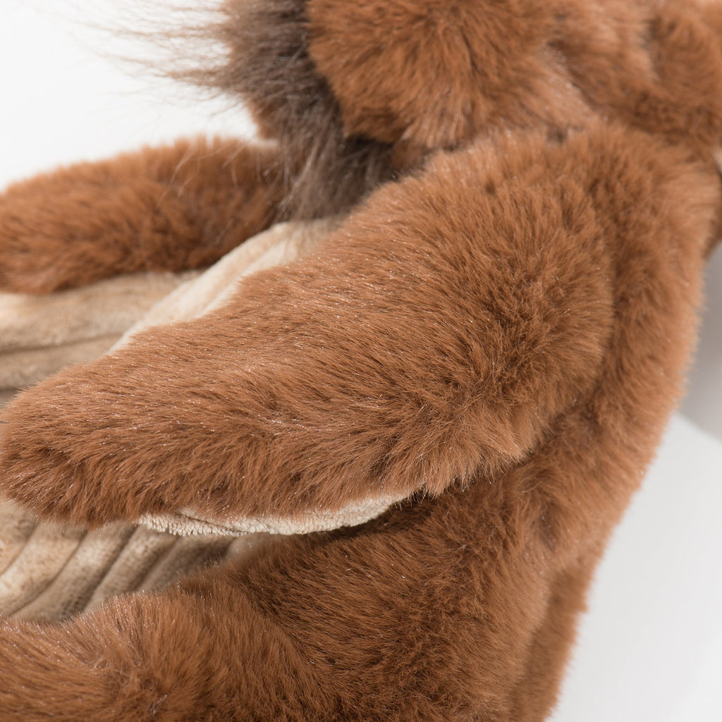Maple Moose X-Brace plush dog toy close-up, brown paw on cream textured panel