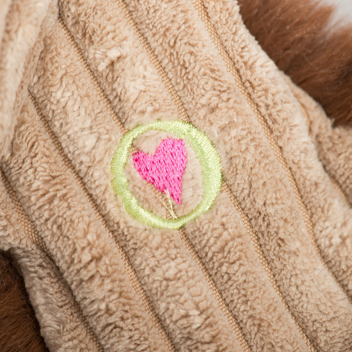 Maple Moose X-Brace plush dog toy close-up, heart patch on cream striped fabric