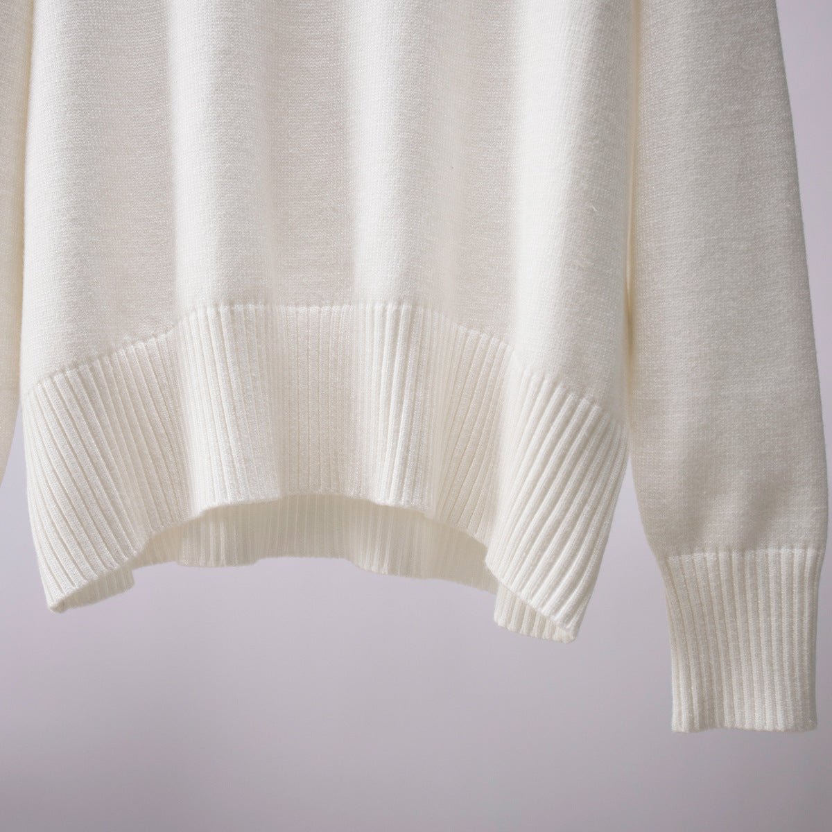 White knit turtleneck pullover sweater close-up of ribbed hem