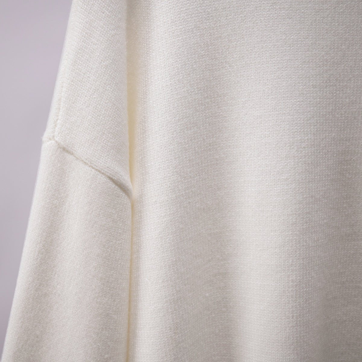 White knit turtleneck pullover sweater close-up of sleeve seam
