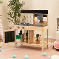 Kids wooden outdoor play kitchen with black countertop, two burners, and removable sinks