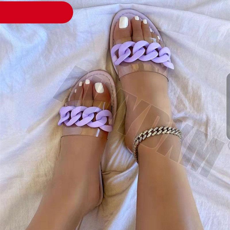 Lilac open-toe flat slide sandals with chunky chain strap on model’s feet