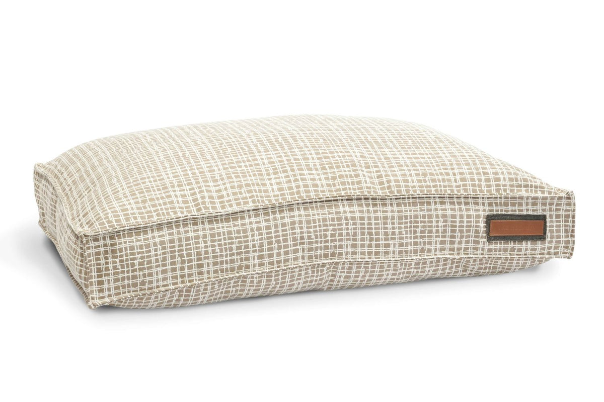 Pet lounger bed with beige-and-white grid fabric, rectangular cushion with side label