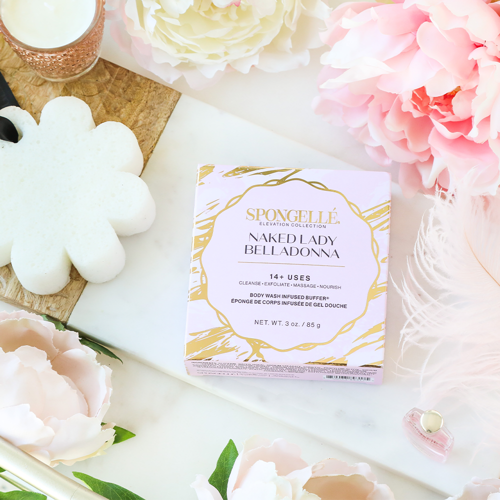 Boxed body buffer with white flower sponge and soft pink petals on display