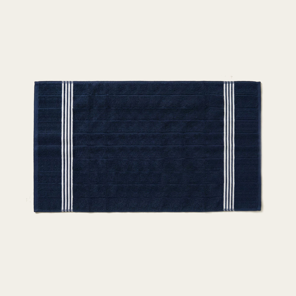 Navy cotton bath sheet with white striped border, rectangular fold