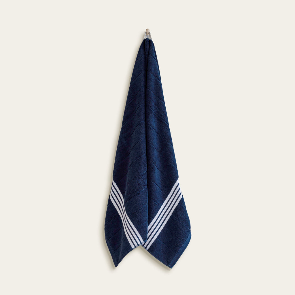 Navy Australian cotton towel with white striped border, hanging flat
