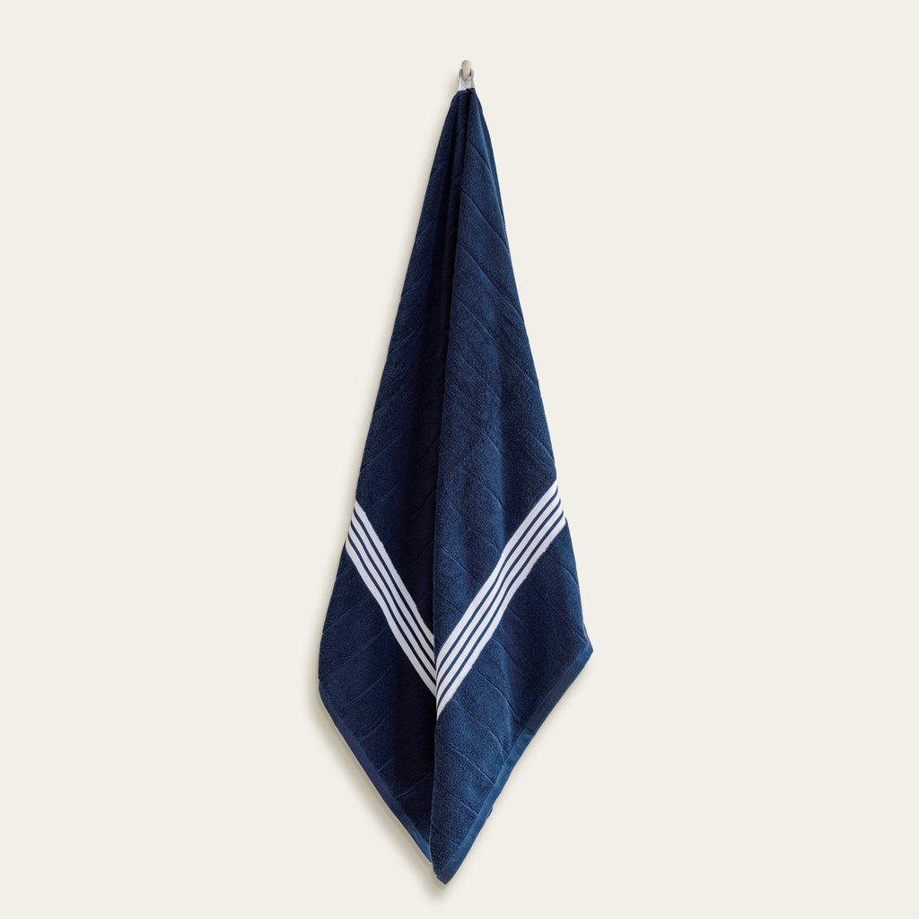Navy Australian cotton towel with white chevron-style border, hanging