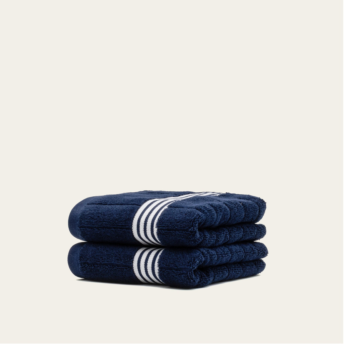 Rolled navy cotton towels with white striped bands, folded into two pieces